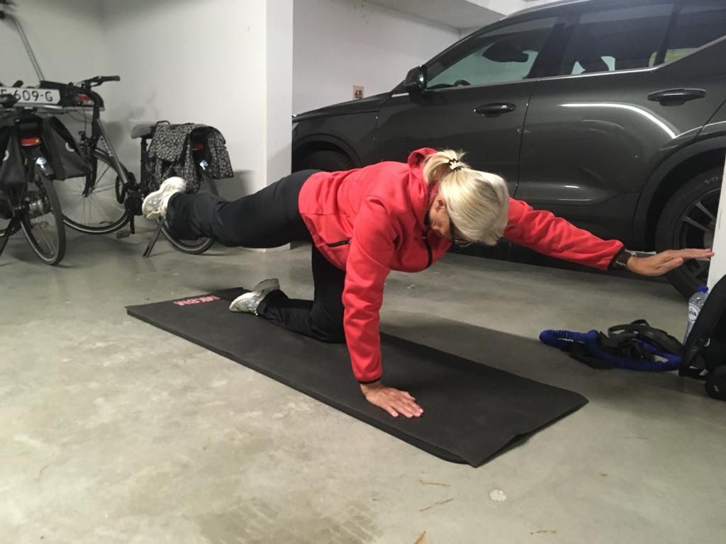 Training op een mat in een garage naast de auto